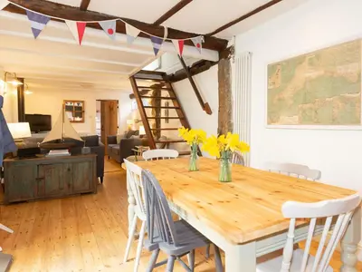 a dining room with a wooden table and chairs at The Sail Loft in St Ives