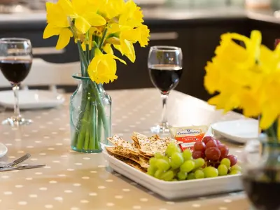 a table with a plate of food and two glasses of wine at The Sail Loft in St Ives