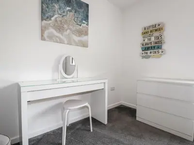 a white desk with a mirror and a stool at Penn-An-Vownder in Newquay