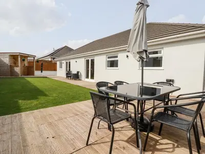 a table and chairs with an umbrella on a patio at Penn-An-Vownder in Newquay