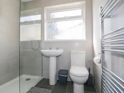a bathroom with a toilet and a sink and a window at Watergate Bay in Liskeard