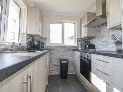 a kitchen with a sink and a stove top oven at Watergate Bay in Liskeard