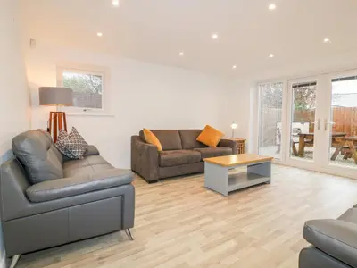 a living room with two couches and a table at Lily Cottage in Camelford