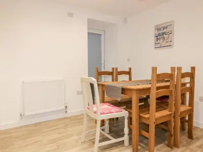 a dining room with a wooden table and chairs at Lily Cottage in Camelford