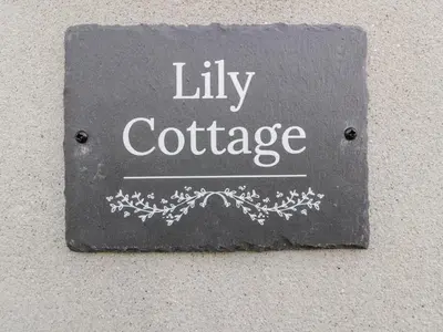 a sign on a wall that reads utility cottage at Lily Cottage in Camelford