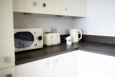 a kitchen counter with a microwave and a toaster oven at Stunning Sea Views, luxury apartment beaches & restaurants are a short walk away in Newquay