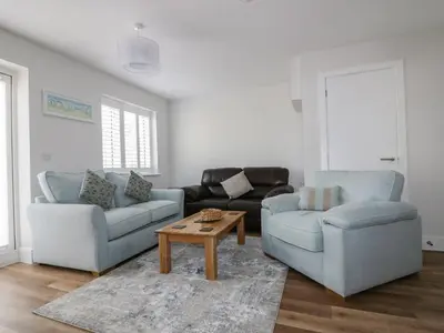 a living room with two couches and a coffee table at The Sand Dunes in Crantock