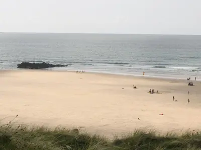 a group of people on a beach near the ocean at Miles Retreat in Hayle