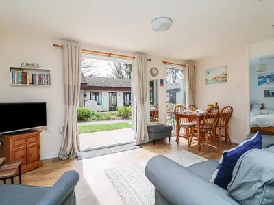 a living room with a couch and a tv and a table at Miles Retreat in Hayle