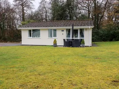 a small white house with a large yard at Blue Sky Cottage in Liskeard