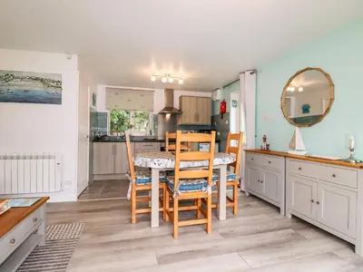 a kitchen and dining room with a table and chairs at Blue Sky Cottage in Liskeard