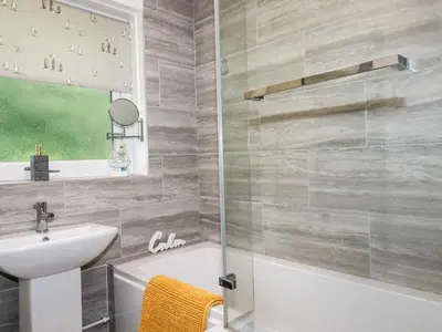 a bathroom with a sink and a toilet and a shower at Blue Sky Cottage in Liskeard