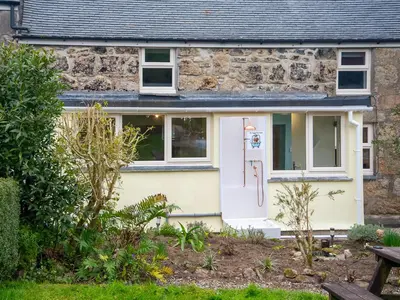 a stone cottage with a white door at Little Trevarrack in Carbis Bay