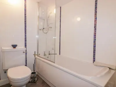 a bathroom with a toilet and a tub and a shower at Hawthorn Cottage in Bodmin