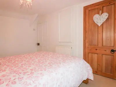 a bedroom with a bed and a wooden door at Hawthorn Cottage in Bodmin