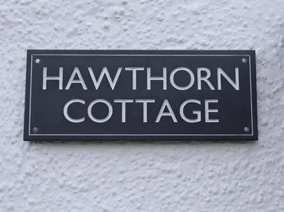 a sign for a hawthorn cottage on a wall at Hawthorn Cottage in Bodmin