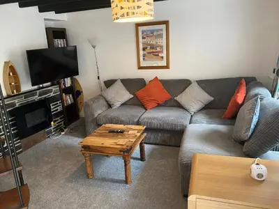 a living room with a couch and a coffee table at Cottage in village of Mevagissey Cornwall Sleeps 4 in Mevagissey