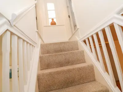 a stairway with a person sitting in a window at Bay Tree Cottage in Looe
