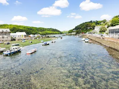 a river with boats docked in a town at Bay Tree Cottage in Looe