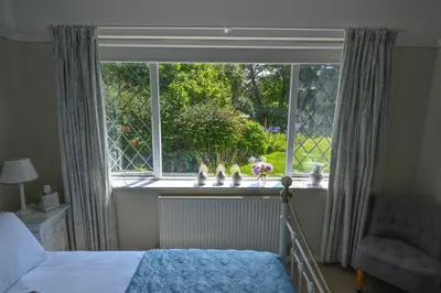 a bedroom with a bed and a large window at Halwell Lodge in St Ives