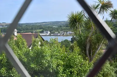 a view of a lake through a fence at Halwell Lodge in St Ives