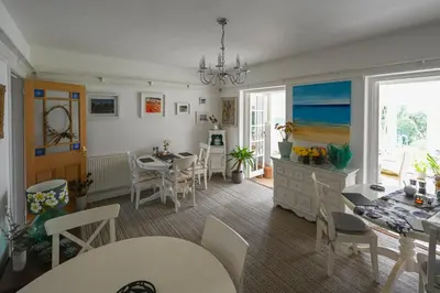 a living room with a table and chairs and a dining room at Halwell Lodge in St Ives
