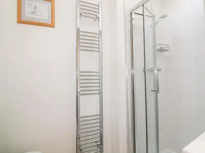 a bathroom with a shower and a glass shower backdoor at Puffin Cottage in Truro