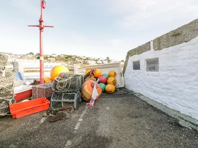a pile of pumpkins and balls sitting on the side of a boat at Puffin Cottage in Truro