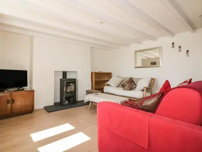 a living room with a red couch and a fireplace at Puffin Cottage in Truro