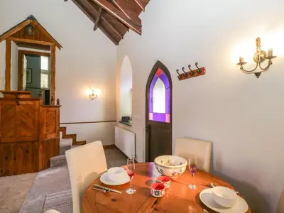 a dining room with a wooden table and chairs at Frogwell Chapel in Callington