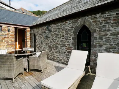 a patio with white chairs and a table at Frogwell Chapel in Callington
