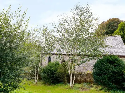 an old stone building with trees in front of it at Frogwell Chapel in Callington