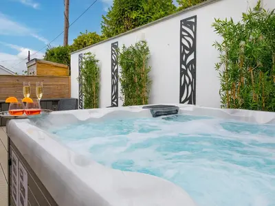 a jacuzzi tub in the backyard of a house at Sea Sands in Penzance