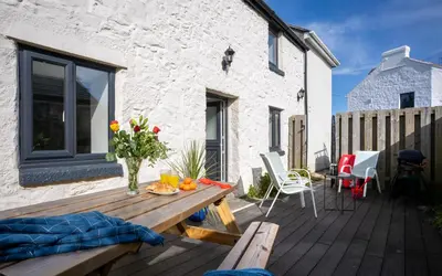a wooden deck with a table and chairs at Rose Cottage in St Ives