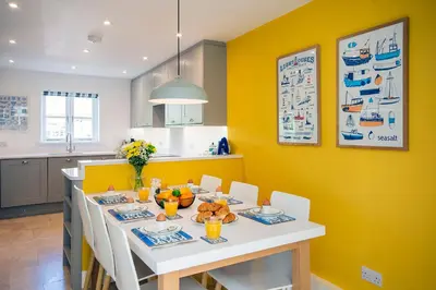 a dining room with a white table and yellow wall at Tall Ships, Charlestown - two ticks from the harbour in Charlestown