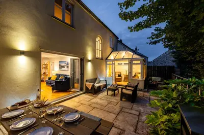 a patio with a table and chairs and a house at Tall Ships, Charlestown - two ticks from the harbour in Charlestown
