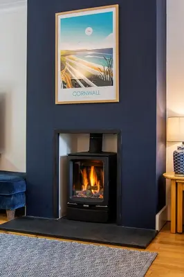 a living room with a fireplace with a picture on the wall at Tall Ships, Charlestown - two ticks from the harbour in Charlestown