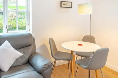 a living room with a couch and a table at Falmouth Bay Holiday Apartments in Falmouth