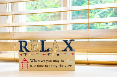 a sign that says relax in front of a window at Falmouth Bay Holiday Apartments in Falmouth