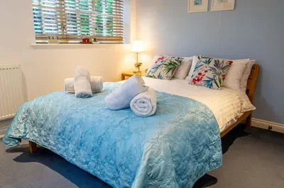 a bedroom with a bed with towels on it at Falmouth Bay Holiday Apartments in Falmouth