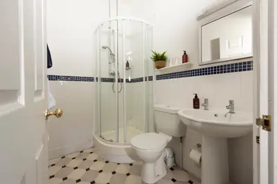 a bathroom with a shower and a toilet and a sink at Stable House in Redruth