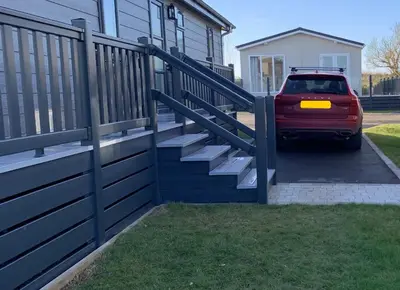 a car parked in front of a fence with stairs at Edge of Padstow, 2 bedroom luxury lodge in Padstow