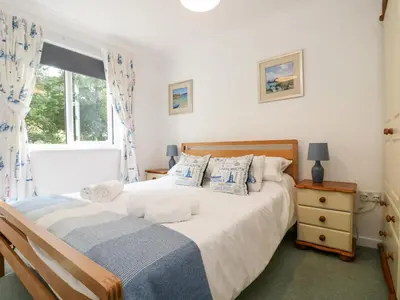 a bedroom with a bed and a window at Robinswood in Falmouth