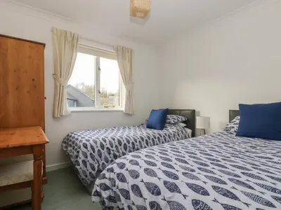 a bedroom with two beds and a window at Robinswood in Falmouth