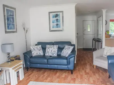 a living room with a blue couch and a chair at Robinswood in Falmouth
