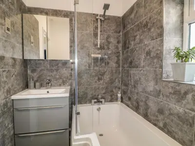 a bathroom with a tub and a sink and a shower at Primrose End in Bude