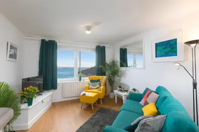 a living room with a blue couch and yellow chairs at 11 Carrack Widden in St Ives