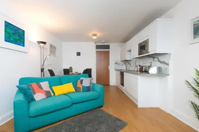 a living room with a blue couch and a kitchen at 11 Carrack Widden in St Ives
