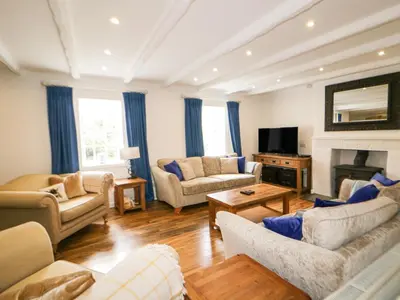 a living room filled with furniture and a fireplace at Great Western Farmhouse in Newquay