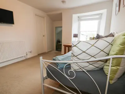a living room with a couch and a window at Great Western Farmhouse in Newquay